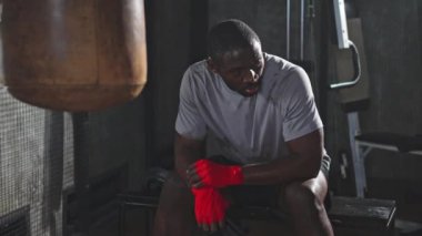 Spor salonunda boksör. Spor salonunda boks antrenmanından sonra kırmızı boks ambalajlı yorgun Afrikalı boksör. Boks müsabakasından sonra güçlü, terli bir sporcu. Spor salonunda antrenman günü