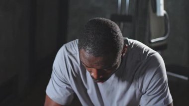 Spor salonunda boksör. Spor salonunda boks antrenmanından sonra kırmızı boks ambalajlı yorgun Afrikalı boksör. Boks müsabakasından sonra güçlü, terli bir sporcu. Spor salonunda antrenman günü