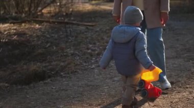 Mutlu bebek dışarıda. Oyuncak arabalı küçük çocuk parkta eğleniyor. Küçük oğlum dışarıda oynarken gülümsüyor. Küçük çocuk doğada dinleniyor. Küçük çocuk yürüyüş yaparken eğleniyor.
