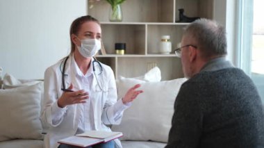 Doktor muayenehanesinde ya da evde yaşlı bir adamı muayene eden kadın doktor. Yaşlı hasta ve doktorun hastane odasında muayeneleri var. Tıbbi sağlık hizmetleri sağlık kontrolü. Doktoru ziyaret et.