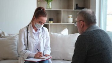 Doktor muayenehanesinde ya da evde yaşlı bir adamı muayene eden kadın doktor. Yaşlı hasta ve doktorun hastane odasında muayeneleri var. Tıbbi sağlık hizmetleri sağlık kontrolü. Doktoru ziyaret et.