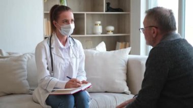 Doktor muayenehanesinde ya da evde yaşlı bir adamı muayene eden kadın doktor. Yaşlı hasta ve doktorun hastane odasında muayeneleri var. Tıbbi sağlık hizmetleri sağlık kontrolü. Doktoru ziyaret et.