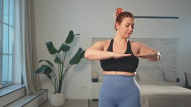 Fitness antrenmanı. Evde spor yapan bir kadın. Artı ev içinde spor egzersizi yapan beden bir kadın. Spor giyimli kız kilo vermek için ağırlık çalışması yapıyor. Spor ve zindelik