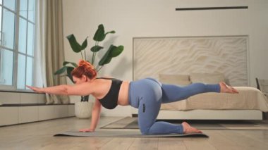Yoga fitness antrenmanı. Evde yoga yapan bir kadın. Artı ev içinde yoga minderiyle spor egzersizi yapan beden bir kadın. Spor giyim bölümündeki kız kilo vermek için antrenman yapıyor. Spor ve zindelik