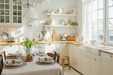İskandinav klasiği beyaz ve ahşap çiçekli minimalist mutfak. Modern beyaz mutfak, çağdaş tarz iç tasarım. Boş parlak beyaz iç mekan, mutfak minimumu