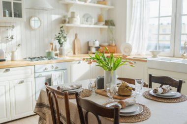 İskandinav klasiği beyaz ve ahşap çiçekli minimalist mutfak. Modern beyaz mutfak, çağdaş tarz iç tasarım. Boş parlak beyaz iç mekan, mutfak minimumu
