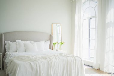 Evin içinde şık bir çatı katı var. Geniş duvarları, geniş pencereleri, büyük yatağı olan geniş bir tasarım dairesi. Minimalist İskandinav tarzında zarif mobilyalarla temiz modern dekorasyon.