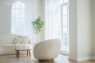 Evin içinde şık bir çatı katı var. Geniş duvarları, geniş pencereleri, beyaz kanepesi ve koltuğu olan geniş bir tasarım dairesi. Minimalist İskandinav tarzında zarif mobilyalarla temiz modern dekorasyon.