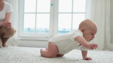 Mutlu bebek. Yatak odasında yerde sürünen, gülen yüzlü, yeni doğmuş şirin bir kız. Bebek dinleniyor. Oturma odasında oynuyor. Evde. Annelik mutlu çocuk bakımı konsepti