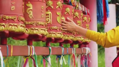 Seyyah kadın eli dokunarak Budist manastırında Budist dua çarkını çeviriyor. Budist taş tapınağında duacı çarkları var. Budizm dini kavramı