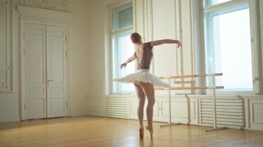 Bale dersinde etekli balerin dans ederek bale yapıyor. Dans stüdyosundaki genç klasik dansçı kadın. Bale sınıfı eğitimi. Bale okulunda dans provası yapan sanatçı kız.
