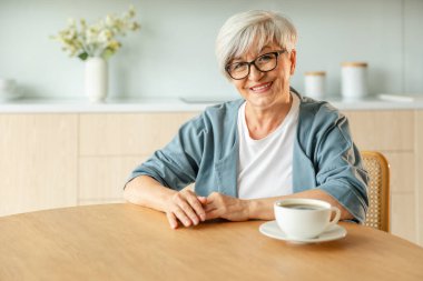Kendine güveni tam orta yaşlı Avrupalı bir kadının portresi. Evde gülümseyen 60 'lı yaşlarda olgun bir kadın. Mutlu, çekici, son sınıf öğrencisi, kamera görüntüsü, yüz portresi. Mutlu insanlar.
