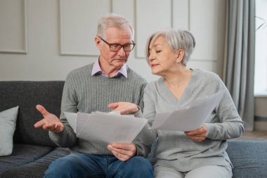 Orta yaşlı, üzgün, hayal kırıklığına uğramış yaşlı çift ellerinde kağıt belgelerle oturuyor. Mutsuz, olgun bir kadın kağıt tasarısı okuyor. Banka yönetiyor. Vergileri hesaplıyor.