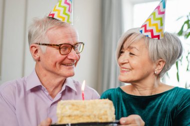 Bir dilek tut. Parti şapkalı son sınıf aile çifti evde birlikte doğum günü kutluyor. Yaşlı kadın doğum günü pastasında yanan mumları üflüyor. Yaşlı adam karısına mutlu yıllar diliyor.