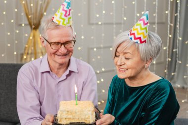 Bir dilek tut. Parti şapkalı son sınıf aile çifti evde birlikte doğum günü kutluyor. Yaşlı adam doğum günü pastasında yanan mumları üflüyor. Yaşlı kadın kocana mutlu yıllar diliyor.
