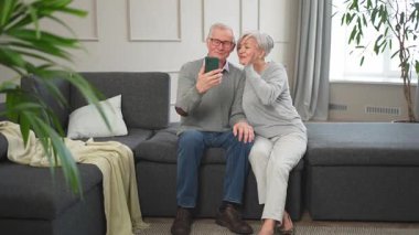 Görüntülü arama. Akıllı telefonlu mutlu son sınıf kadın erkek video görüşmesi yapıyor. Olgun yaşlı büyükbaba internette konuşuyor. Eski nesil modern teknoloji kullanımı. Sanal toplantı çevrimiçi sohbet