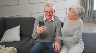Görüntülü arama. Akıllı telefonlu mutlu son sınıf kadın erkek video görüşmesi yapıyor. Olgun yaşlı büyükbaba internette konuşuyor. Eski nesil modern teknoloji kullanımı. Sanal toplantı çevrimiçi sohbet
