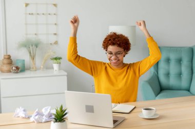 Heyecanlı mutlu Afro-Amerikan kadın mutluluğu kazananı. Dizüstü bilgisayara bakan kız öğrenci sınavı geçti. Harika haberler okuyor. Çevrimiçi ihaleyi kazanma konusunda iyi sonuç alıyor. Kazanan jest