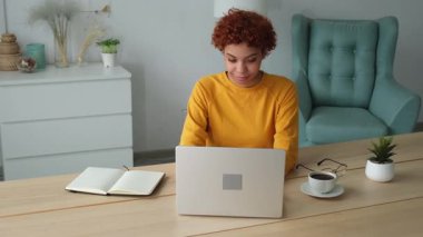 African american girl using laptop computer having video chat at home. Young woman having virtual meeting online chat video call conference sitting on couch. Work learning from home, remote teacher