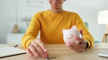 Birikmiş paralar. Gelecek için para biriktirme işi. Elinde pembe kumbarası olan Afro-Amerikalı bir kız para koyuyor. Bütçe emekliliği Finansal plan yatırım