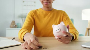 Birikmiş paralar. Gelecek için para biriktirme işi. Elinde pembe kumbarası olan Afro-Amerikalı bir kız para koyuyor. Bütçe emekliliği Finansal plan yatırım