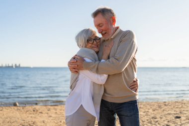Yaşlı bir çift kumsalda yürüyüş yaparken kucaklaşıp eğleniyorlar. Yaşlı karı şefkatle kucaklaşıyor aşk tatlı bir bağın tadını çıkarıyor. Büyükannem ve büyükbabam birlikte. Aile anı aşkı