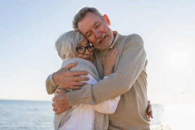 Yaşlı bir çift kumsalda yürüyüş yaparken kucaklaşıp eğleniyorlar. Yaşlı karı şefkatle kucaklaşıyor aşk tatlı bir bağın tadını çıkarıyor. Büyükannem ve büyükbabam birlikte. Aile anı aşkı