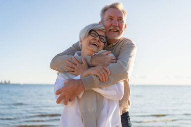 Yaşlı bir çift kumsalda yürüyüş yaparken kucaklaşıp eğleniyorlar. Yaşlı karı şefkatle kucaklaşıyor aşk tatlı bir bağın tadını çıkarıyor. Büyükannem ve büyükbabam birlikte. Aile anı aşkı