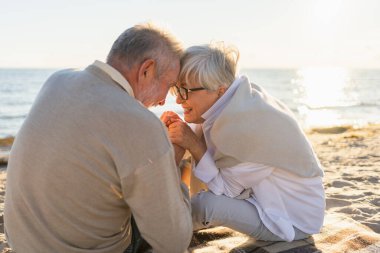 Sahilde oturmuş el ele tutuşan olgun bir çift dışarıda eğleniyor. Yaşlı karı şefkatle el ele tutuşuyor. Büyükannem ve büyükbabam birlikte. Aile âşkı