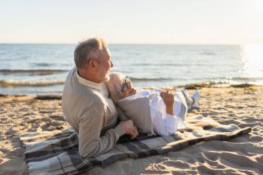 Sahilde oturmuş, dışarıda eğlenen olgun bir çift. Yaşlı karı şefkatle kucaklaşıyor aşk tatlı bir bağın tadını çıkarıyor. Büyükannem ve büyükbabam birlikte. Aile anı aşkı