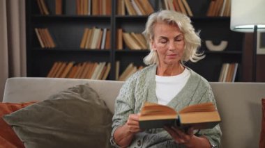 Huzur, evde kitap okuyan yaşlı ve yaşlı bir kadın. Olgun bir kadın dinleniyor. Evde tek başına sakin bir gün geçiriyor. Yetişkin kadın boş zamanlarını kitap okuyarak geçiriyor. Emeklilik konsepti