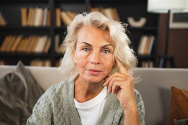 Kendine güveni tam orta yaşlı Avrupalı bir kadının portresi. Evde gülümseyen 60 'lı yaşlarda olgun bir kadın. Mutlu, çekici, son sınıf öğrencisi, kamera görüntüsü, yüz portresi. Mutlu insanlar.