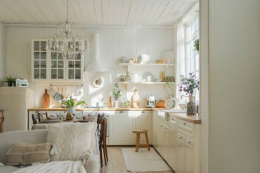 İskandinav klasiği beyaz ve ahşap çiçekli minimalist mutfak. Modern beyaz mutfak, çağdaş tarz iç tasarım. Boş parlak beyaz iç mekan, mutfak minimumu