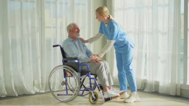 Emeklilik sağlık hizmetlerine destek ol. Hemşire tekerlekli sandalyedeki yaşlı adama yardım ediyor. Hasta ve kadın tıbbi bakım için huzurevinde. Engelli insanlar için tekerlekli sandalyede felçli bir adama bakan hemşire.