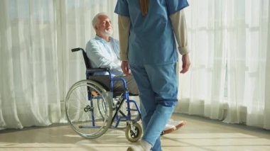 Emeklilik sağlık hizmetlerine destek ol. Hemşire tekerlekli sandalyedeki yaşlı adama yardım ediyor. Hasta ve kadın tıbbi bakım için huzurevinde. Engelli insanlar için tekerlekli sandalyede felçli bir adama bakan hemşire.