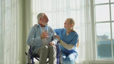 Emeklilik sağlık hizmetlerine destek ol. Hemşire tekerlekli sandalyedeki yaşlı adama yardım ediyor. Hasta ve kadın tıbbi bakım için huzurevinde. Engelli insanlar için tekerlekli sandalyede felçli bir adama bakan hemşire.