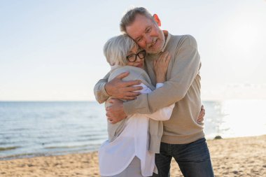 Yaşlı bir çift kumsalda yürüyüş yaparken kucaklaşıp eğleniyorlar. Yaşlı karı şefkatle kucaklaşıyor aşk tatlı bir bağın tadını çıkarıyor. Büyükannem ve büyükbabam birlikte. Aile anı aşkı