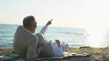 Sahilde oturmuş, dışarıda eğlenen olgun bir çift. Yaşlı karı şefkatle kucaklaşıyor aşk tatlı bir bağın tadını çıkarıyor. Büyükannem ve büyükbabam birlikte. Aile anı aşkı