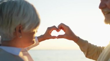 Aşk, barışı şekillendirir. Yaşlı çift elleriyle kalp şekli yaratıyor. Yetişkin, olgun koca eşi kalp işareti gösteriyor. Mutlu emekliler ailesi. Seni seviyorum Sevgililer Günü 'n kutlu olsun