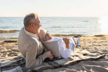 Sahilde oturmuş, dışarıda eğlenen olgun bir çift. Yaşlı karı şefkatle kucaklaşıyor aşk tatlı bir bağın tadını çıkarıyor. Büyükannem ve büyükbabam birlikte. Aile anı aşkı