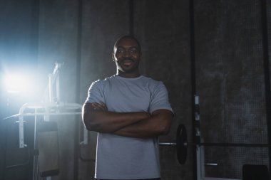 Beden eğitiminde spor. Spor salonunda motivasyon ve sağlık enerjisiyle eğitime hazır Afro-Amerikan bir adamın portresi. Atletizm koçu kişisel antrenör fitness kulübü sahibi. Sağlıklı yaşam tarzı