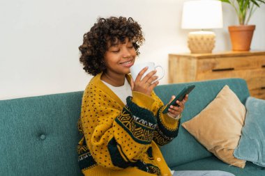 İyi sabahlar. Elinde akıllı telefon olan Afrikalı bir kız sosyal medya uygulamaları kullanarak cep telefonu sörfü yapan bir kadının koltuğunda oturuyor. İnternet üzerinden haber alışverişi cep telefonu bağımlılığı