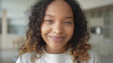 Afro saç stili gülümseyen güzel bir Afrikalı Amerikalı kız. Genç mutlu zenci kızın portresini yakından çek. Kıvırcık saçlı, gülen genç bir Afrikalı kadın. Özgürlük mutluluğu tasasız mutlu insanlar konsepti