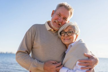 Yaşlı bir çift kumsalda yürüyüş yaparken kucaklaşıp eğleniyorlar. Yaşlı karı şefkatle kucaklaşıyor aşk tatlı bir bağın tadını çıkarıyor. Büyükannem ve büyükbabam birlikte. Aile anı aşkı