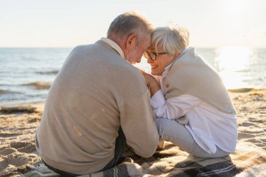 Sahilde oturmuş el ele tutuşan olgun bir çift dışarıda eğleniyor. Yaşlı karı şefkatle el ele tutuşuyor. Büyükannem ve büyükbabam birlikte. Aile âşkı