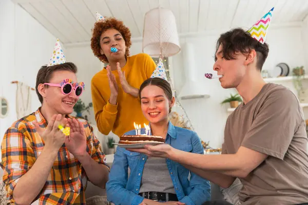 Bir dilek tut. Parti şapkası takan bir kadın doğum günü pastasında yanan mumları üflüyor. Doğum günün kutlu olsun. Bir grup arkadaş kızın doğum gününü kutluyor. İnsanlar doğum gününü evde partiyle kutluyor.