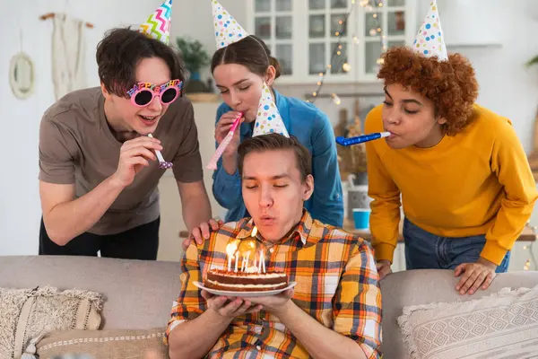 Bir dilek tut. Parti şapkası takmış bir adam doğum günü pastasında yanan mumları üflüyor. Doğum günün kutlu olsun. Arkadaş grubu adama mutlu yıllar diliyor. İnsanlar doğum gününü evde partiyle kutluyor.