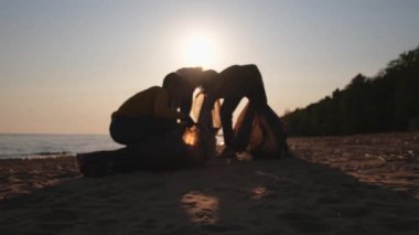 Dünya günü. Gönüllü eylemciler sahil bölgesindeki çöpleri topluyor. Kadınlar ve erkekler okyanus kıyısındaki çöp torbasına plastik çöp koyar. Çevre koruma kıyı bölgesi temizliği