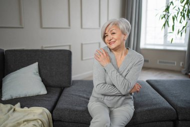 Kendine güveni tam orta yaşlı Avrupalı bir kadının portresi. Evde gülümseyen 60 'lı yaşlarda olgun bir kadın. Mutlu, çekici, son sınıf öğrencisi, kamera görüntüsü, yüz portresi. Mutlu insanlar.