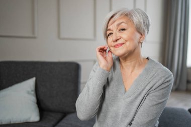 Kendine güveni tam orta yaşlı Avrupalı bir kadının portresi. Evde gülümseyen 60 'lı yaşlarda olgun bir kadın. Mutlu, çekici, son sınıf öğrencisi, kamera görüntüsü, yüz portresi. Mutlu insanlar.